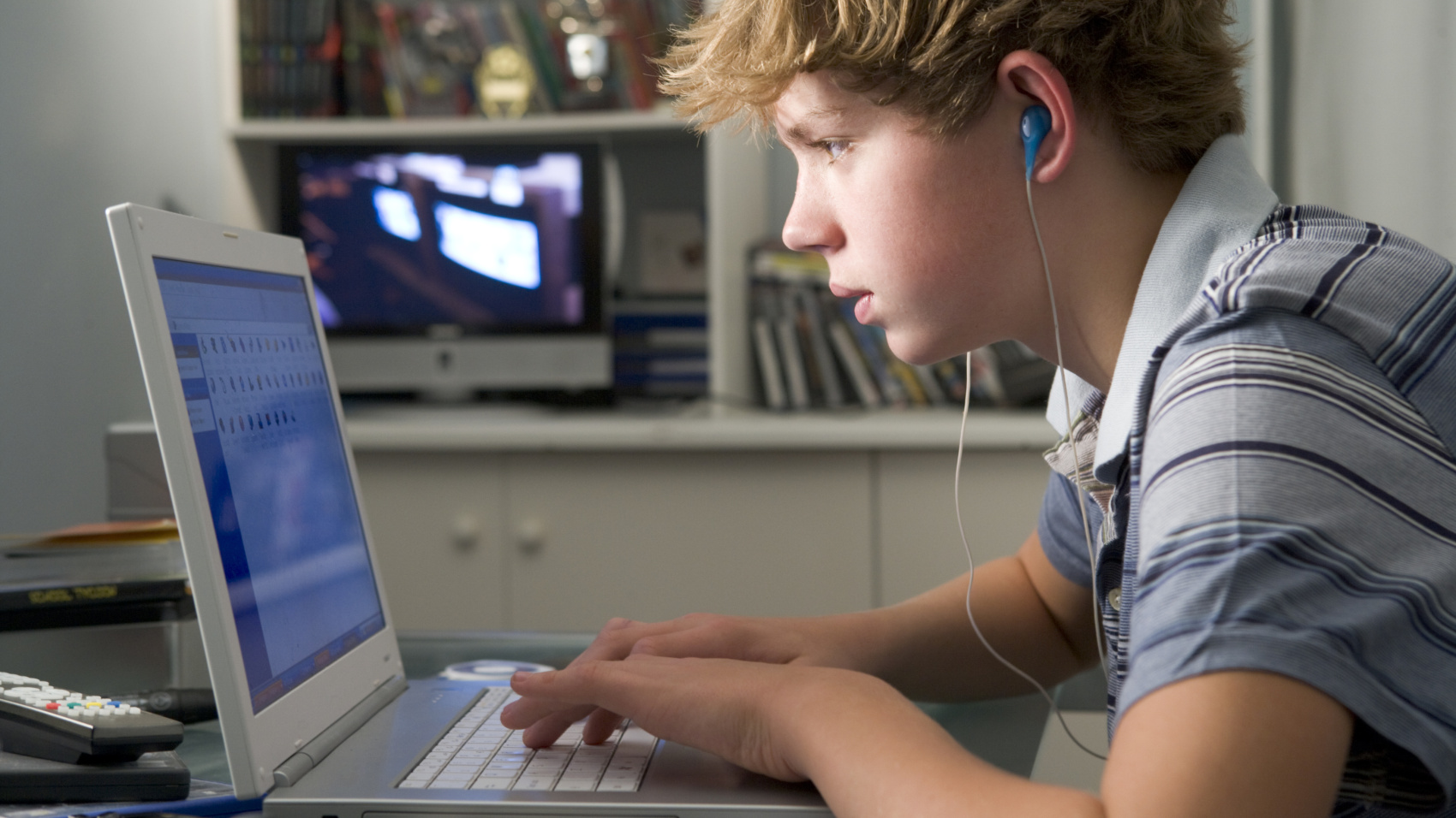 A young man look intently at his laptop
